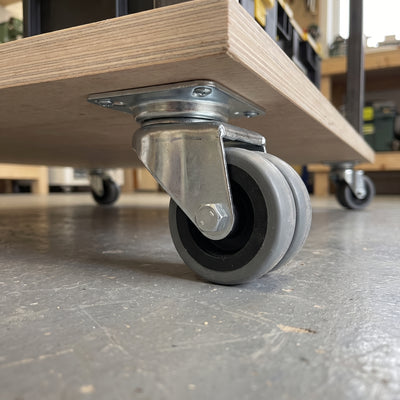 50mm twin wheel top plate castor with grey rubber wheels screwed under a plywood mobile workbench