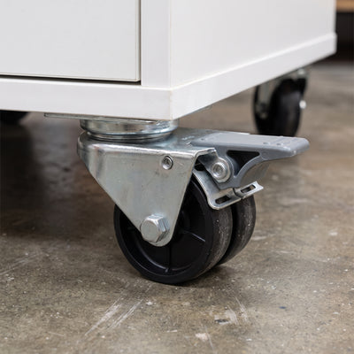 75mm twin wheel braked top plate castor with grey foot brake fitted under a white mobile storage cabinet