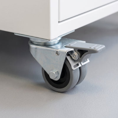 75mm twin wheel total lock top plate castor with grey rubber wheels fitted under a white equipment cabinet on vinyl flooring