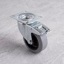 100mm braked swivel top plate castor grey rubber wheel 150kg, high angle view on grey marble