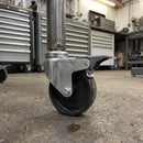 100mm braked swivel castor fitted to a mobile work table in a workshop