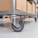 100mm braked swivel castor grey rubber on polypropylene wheel M10 bolt hole on a warehouse stock trolley