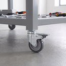 100mm braked swivel bolt hole castor with grey rubber wheel fitted to a mobile workbench tube leg