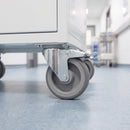 100mm braked top plate castor with grey TPR wheel under a white linen trolley on a safety vinyl corridor floor