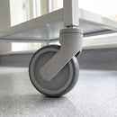 100mm grey swivel bolt hole castor with thermoplastic rubber wheel bolted under a white medical trolley leg