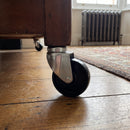 100mm swivel bolt hole castor with black polypropylene wheel fitted to a wooden furniture leg