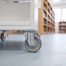100mm swivel top plate castor with grey TPR wheel under a white school library book trolley on vinyl flooring