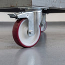 125mm braked large-plate castor with maroon polyurethane wheel under a grey steel machine trolley