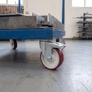 125mm braked large-plate castor with maroon polyurethane wheel under a blue steel platform truck carrying steel plate