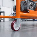 125mm red polyurethane bolt hole castor on an orange steel machine stand carrying a gearbox