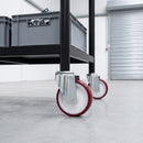 125mm red polyurethane swivel castors on a black steel warehouse shelf trolley