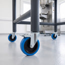 160mm blue braked bolt hole castor fitted to a steel machine stand leg in a factory