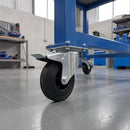 160mm braked top plate castor with black rubber wheel under a blue steel machine stand in a workshop