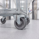 160mm braked top plate castor with grey TPR wheel under a galvanised supply cage trolley in a service corridor