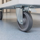 160mm directional lock castor with grey TPR wheel under a white hospital linen trolley on a vinyl corridor floor