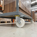 160mm directional lock castor white nylon wheel under a grey furniture dolly carrying a wardrobe