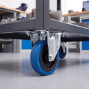 160mm fixed top plate castor with blue non-marking rubber wheel bolted under a steel industrial cart in a workshop