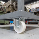 160mm fixed castor white nylon wheel bolted under a grey equipment cart carrying a gearbox