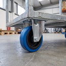 160mm fixed top plate castor with blue non-marking rubber wheel bolted under a galvanised steel warehouse platform trolley