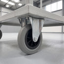160mm fixed top plate castor with grey ribbed rubber wheel bolted under a grey steel warehouse platform trolley