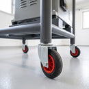 160mm black rubber swivel bolt hole castor fitted to a steel machine stand leg in a factory