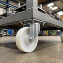 160mm swivel castor with white nylon wheel bolted with nuts under a grey industrial trolley
