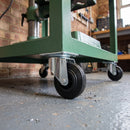 160mm swivel top plate castor with black rubber wheel under a green steel workshop machine stand