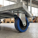 160mm swivel top plate castor with blue non-marking rubber wheel bolted under a galvanised steel warehouse platform trolley