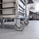 160mm swivel top plate castor with grey TPR wheel under a stainless steel catering trolley on a resin kitchen floor