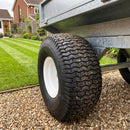 Turf tread tyre fitted to a galvanised garden tipping trailer on a gravel drive beside a striped lawn