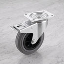 200mm braked swivel top plate castor grey rubber wheel 205kg, high angle view on grey marble