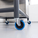 200mm blue braked bolt hole castor fitted to a steel machine stand leg in a factory