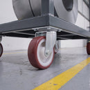 200mm swivel castor with red polyurethane wheel under a grey steel platform truck carrying a steel coil