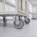 200mm swivel top plate castor with grey TPR wheel under a white steel linen cage trolley in a service corridor