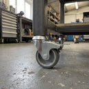 50mm braked grey rubber bolt hole castor fitted to a mobile workbench in a workshop