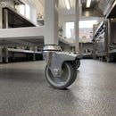 50mm braked grey rubber bolt hole castor fitted to a catering trolley in a commercial kitchen