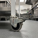 50mm braked grey rubber bolt hole castor fitted to a catering trolley in a commercial kitchen
