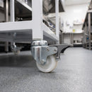 50mm braked white nylon bolt hole castor fitted to a catering trolley in a commercial kitchen