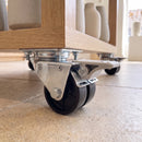 50mm black twin wheel braked swivel castor with top plate bolted to an oak shop display plinth