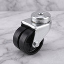 50mm twin wheel swivel bolt hole castor with black polypropylene wheels on light grey marble, high-angle three-quarter view