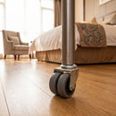 50mm twin wheel grey rubber bolt hole castor fitted to the steel tube leg of a mobile side table in a hotel room