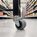 50mm twin wheel grey rubber bolt hole castor fitted under the leg of a retail cart in a supermarket aisle