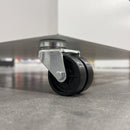 50mm twin wheel bolt hole castor with black polypropylene wheels fitted under a white retail display unit