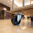 50mm twin wheel top plate castor fitted under a hotel luggage trolley in a hotel lobby
