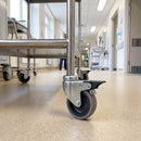 75mm braked grey rubber castor fitted to a medical trolley