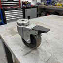 75mm braked bolt hole castor with grey rubber wheel on a workshop bench