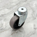 75mm swivel bolt hole castor with grey rubber tyre on black polypropylene centre on light grey marble, high-angle three-quarter view