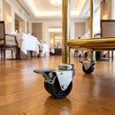 75mm twin wheel braked bolt hole castor fitted to the brass tube leg of a hotel restaurant serving trolley