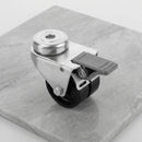 75mm twin wheel braked bolt hole castor with black polypropylene wheels and grey foot brake on light grey marble, 45 degree three-quarter view from a steep high angle