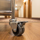75mm twin wheel braked grey rubber bolt hole castor fitted to the chrome tube leg of a hotel housekeeping trolley